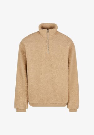 Bež flis pulover z visokim ovratnikom in pol zadrgo. Ima mehak, teksturiran videz ter elastične manšete na zapestjih in robu.