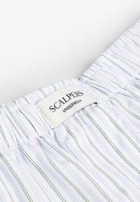 Ropa interior blanca con rayas, que cuenta con una cintura fruncida y una etiqueta que dice "SCALPERS UNDERWEAR" en texto negro.