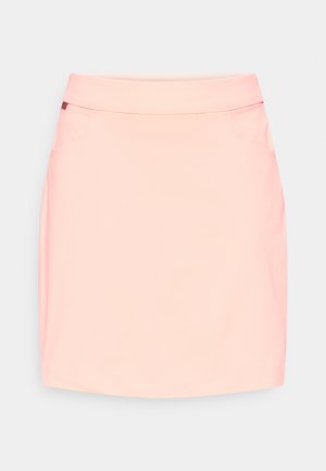 Peach-colored mini skirt with a smooth texture, flat waistband, two side pockets, and a slight curvature at the hem.