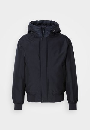 Veste noire à capuche avec fermeture éclair à l'avant, poignets et ourlet élastiques. Caractérisée par une finition lisse et mate, avec un design minimaliste, adaptée pour un port décontracté.