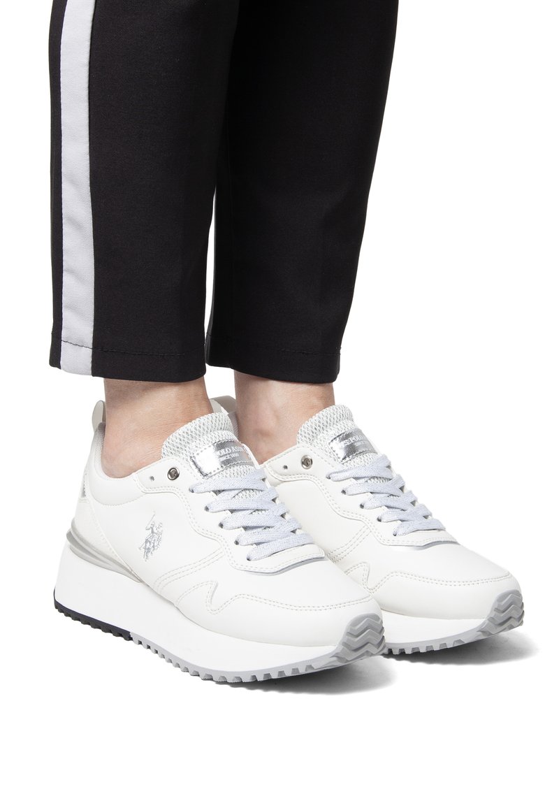 Witte sport sneakers met een gladde synthetische bovenkant, zilveren accenten en een gestructureerde zool. Vetersluiting ontwerp met een mesh tong en logo-detail.