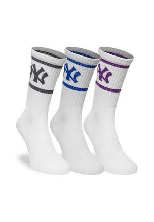 Tre calze bianche con polsini a coste, ciascuna con un logo dei New York Yankees di colore diverso e una striscia abbinata in grigio, blu e viola.