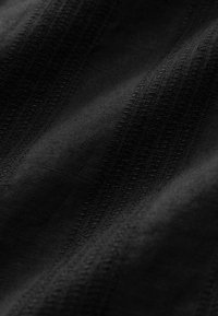 Tissu noir avec une surface texturée, présentant de subtiles rayures tissées. Le matériau semble lisse et légèrement brillant.