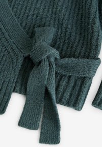 Strickpullover in dunklem Petrol, mit gerippter Textur und einem gebundenen Taillengürtel. Lange Ärmel und ein V-Ausschnitt-Design. Weiches Strickmaterial.