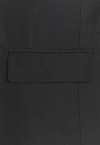 Černá látka s hladkou texturou a obdélníkovým klopovým kapsou. Design je čistý s jemným vzorem tkaní.