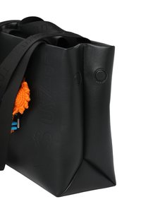 Zwarte leren boodschappentas met geperst logo, twee ronde sluitingen en een oranje gestructureerd accessoire eraan bevestigd. Voorzien van twee zwarte hengsels.