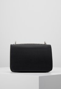 Borsa nera con una forma strutturata, materiale testurizzato e dettagli in catena argentata sulla parte superiore. Design semplice senza ulteriori motivi.