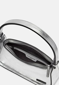 Metallisch silberne Handtasche mit einem strukturierten Design, ausgestattet mit einem oberen Griff, einem mit Reißverschluss verschlossenen Hauptfach und einem schwarzen Innenfutter.