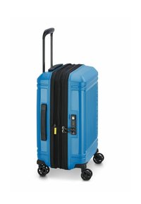 Maleta rígida azul con superficie texturizada, cremallera negra, candado de combinación, asa telescópica y cuatro ruedas giratorias.