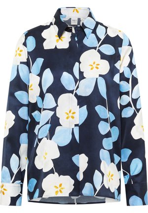 Marineblå skjorte med knapper, der har store hvide og lyseblå blomster mønstre med gule midter. Lavet af glat stof, inkluderer en klassisk krave.