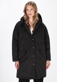 Sort parka med hætte, knaplukning og to sidelommer. Fremstillet af let, glat stof med en afslappet pasform, velegnet til lag-på-lag stil.