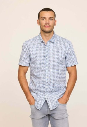 Chemise à manches courtes boutonnée en bleu clair avec un motif imprimé. Dotée d'un col pointu et d'une coupe décontractée. Texture de tissu casual.