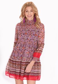Rochie cu mânecă lungă, prezentând un imprimeu floral violet, guler volanat și o fustă evazată cu accente de model roșu și maro.