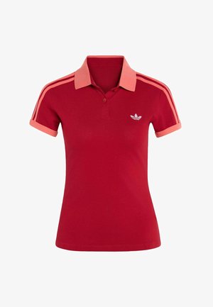 Czerwona koszulka polo z krótkim rękawem, koralowym kołnierzykiem i mankietami, koralowymi paskami na ramionach oraz białym logo Adidas trefoil na piersi.