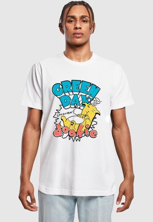 White cotton t-shirt featuring a colorful graphic design of a yellow cartoon dog and text "GREEN DAY" and "dookie" in bold letters.