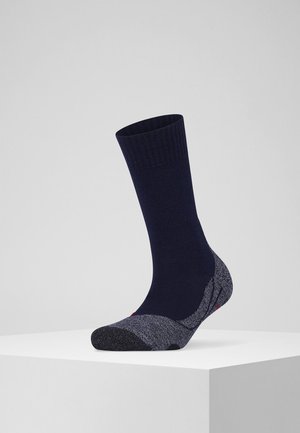 Calcetín azul marino con acentos oscuros gris texturizados, parte superior con canalé y secciones de talón y puntera reforzadas. Presenta una tela suave y duradera.