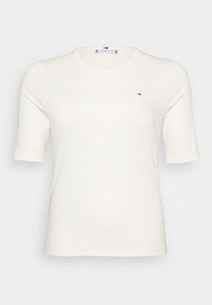 T-shirt de manga curta, com nervuras, na cor creme, com um pequeno logótipo no lado esquerdo do peito. Design casual e ajustado, adequado para várias ocasiões.