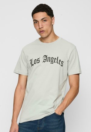 Hellgraues Baumwoll-T-Shirt mit kurzen Ärmeln, das schwarzen Text in fetter, gotischer Schrift zeigt, der "Los Angeles" liest. Lässige Passform.
