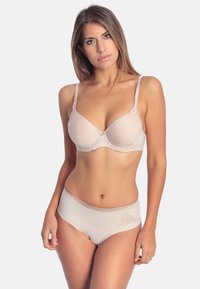 Beige bras with molded cups and adjustable straps, paired with high-waisted panties featuring floral embroidery and a smooth texture.