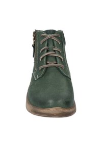 Botín de cuero verde hasta el tobillo con un acabado texturizado, presenta cordones marrones, un cierre con cremallera en el lateral y una suela de color claro.