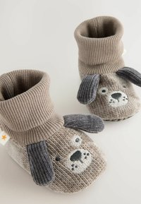 Beige Strümpfe für Hunde aus Strick, mit geripptem Bündchen, bestickten Gesichtdetails und grauen Plüschohren. Weicher Texturaufbau.