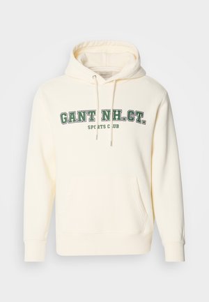 Crème kleurige hoodie met een kangoeroezak, een capuchon met trekkoord en groene opdruk "GANT NH. CT." en "SPORTS CLUB" op de voorkant.