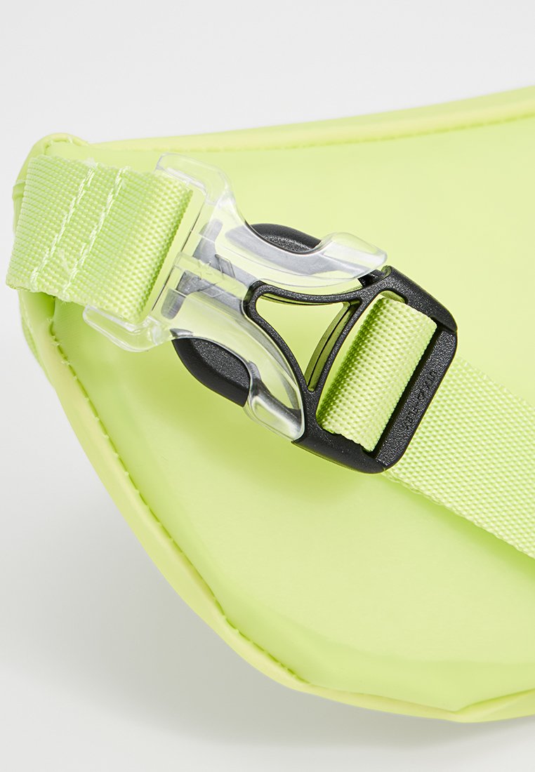 Bolsa resistente al agua de color verde lima brillante con una superficie texturizada, que presenta un broche de plástico negro y una correa ajustable.
