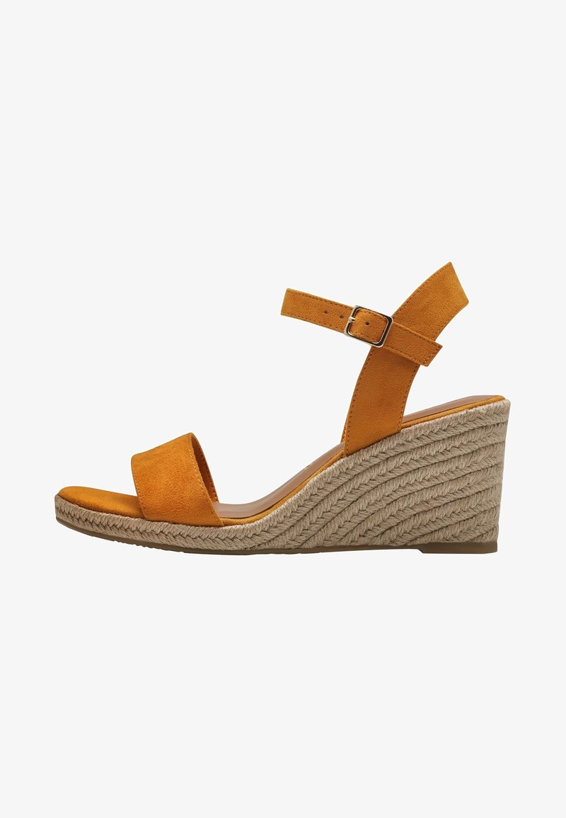 Yellow suede wedge sandal with a wide front strap and ankle strap, featuring a silver buckle. Wedge covered in woven rope texture.