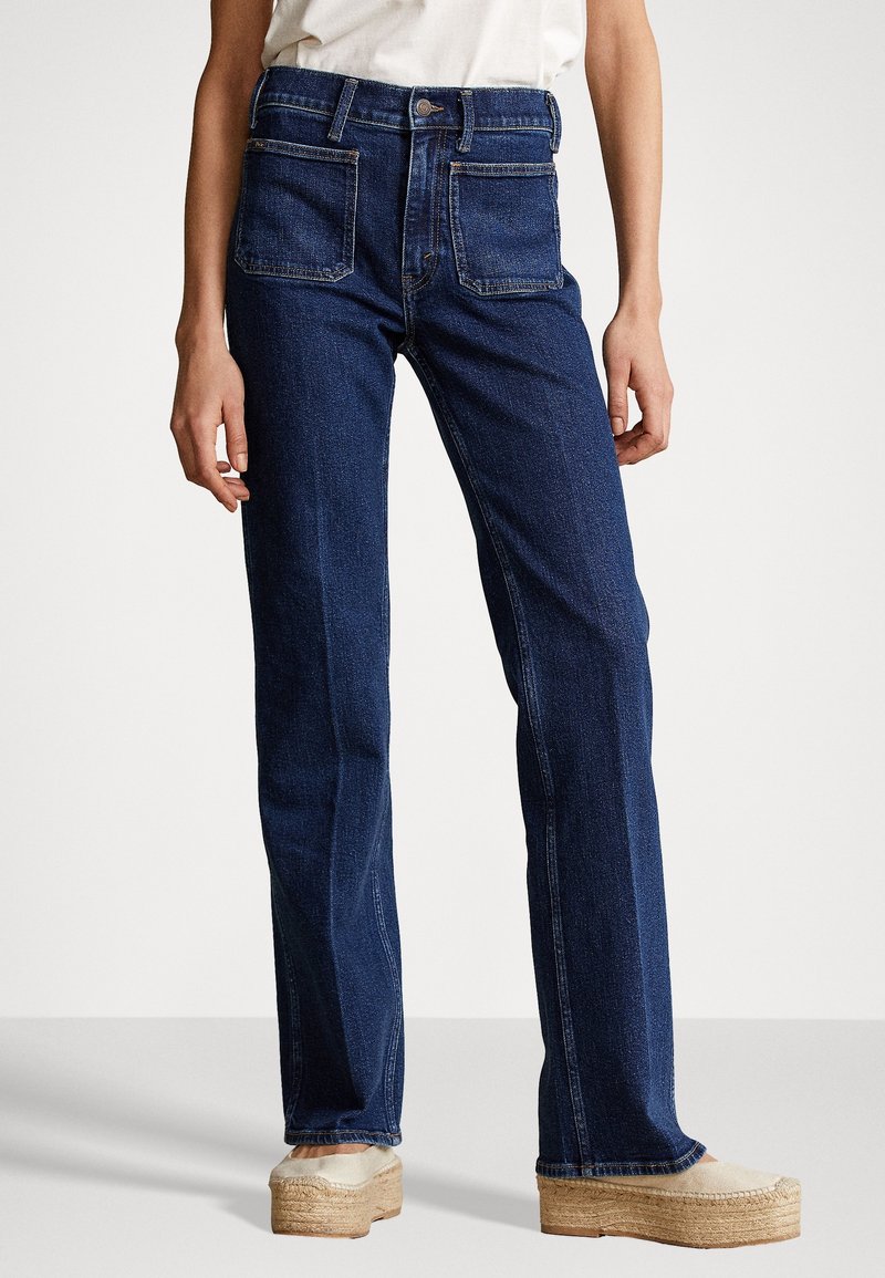 Jeans de mezclilla de tiro alto en azul oscuro con pierna recta, que cuentan con bolsillos delanteros y traseros y un cierre de botón clásico.