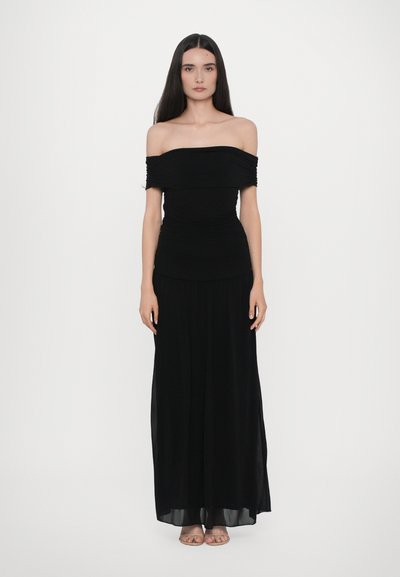 Zwarte off-shoulder maxi-jurk met geplooid lijfje en vloeiende rok; de stof is glad en lichtgewicht, wat een zachte silhoët creëert.
