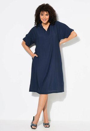 Navyblaues Kleid mit Polo-Kragen und kurzen Ärmeln, ausgestattet mit Seitentaschen und einem lockeren Schnitt, aus leichtem Stoff gefertigt.