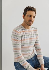 Gestreepte trui van zachte katoen in pastelkleuren zoals perzik, groen en blauw. Heeft een ronde hals en ribgebreide manchetten.