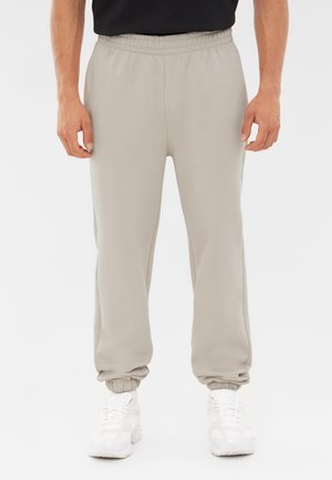Lichtgrijze joggers met een elastische tailleband, opgerolde enkels en een zachte stof, aangevuld met een losse pasvorm voor comfort.
