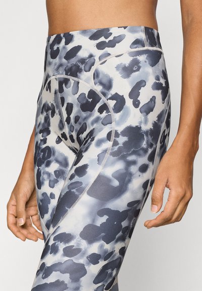 High-waisted leggings in a blue and gray abstract pattern. Made of stretch fabric with flat seams and a smooth texture. Close-fitting design.