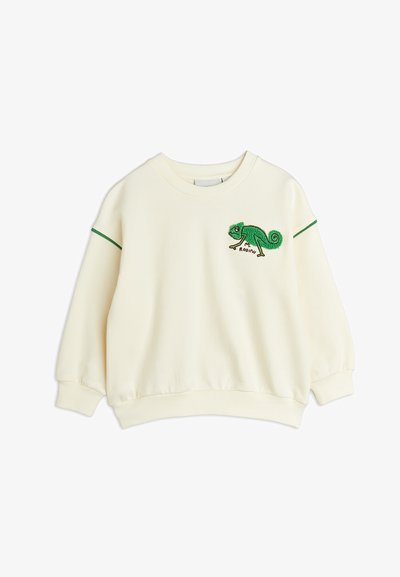 Felpa color crema con ricamo di un camaleonte verde. Presenta polsini e orlo a costine, e strisce verdi di accento sulle maniche.