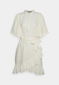 Robe portefeuille crème à manches courtes avec ourlet à volants, boutonnée sur le devant, col montant, ceinture à nouer et motif subtil à pois texturés.