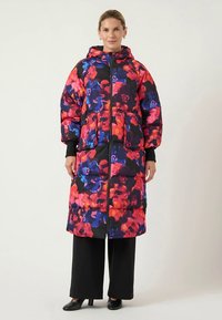 Kurtka puchowa w żywy wzór kwiatowy z różowymi, fioletowymi i niebieskimi odcieniami. Posiada kaptur, zamek błyskawiczny z przodu oraz dwie duże kieszenie.
