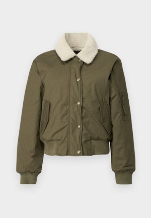 Veste bomber vert olive avec un col en fourrure crème, des poignets et un ourlet côtelés, deux poches avant et une poche à épaule zippée.
