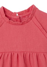 Korallenrosa Kleid mit einem strukturierten, gerippten Muster, das eine geraffte Taille und eine Schlitzöffnung am Rücken sowie einen gerafften Ausschnitt hat.