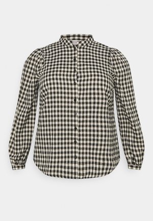 Blouse à carreaux noir et blanc avec un col mandarin, des manches longues bouffantes et une fermeture boutonnée sur le devant. Fabriquée dans un tissu doux.