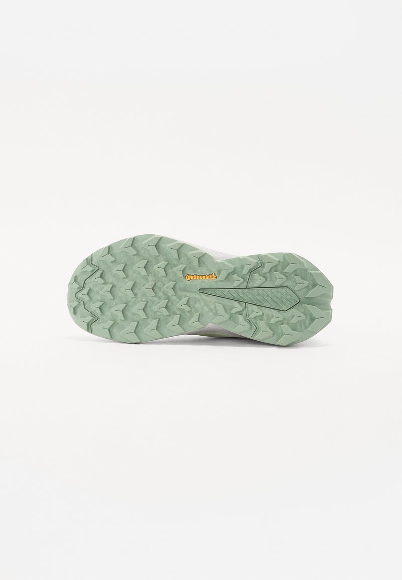 Suela de zapato con un diseño texturizado que presenta goma verde y un logotipo distintivo de Continental. Los elementos de tracción están claramente definidos.