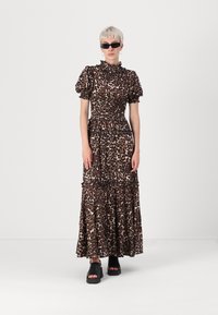 Maksi obleka s leopardjim vzorcem, napihnjenimi rokavi, nabrano telo in plisejska krila. V kombinaciji z debelimi črnimi platformami in temnimi sončnimi očali.