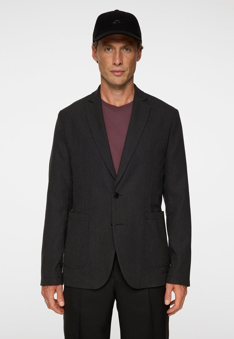 Blazer grigio scuro in una vestibilità su misura, con chiusura a un bottone, due tasche frontali, rever a punta, abbinato a una camicia bordeaux.