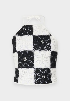 Fekete és fehér horgolt pántos felső, sakktáblás mintával, dekoratív motívumokkal és nyakba köthető záródással.
