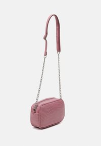 Borsa a tracolla in faux-coccodrillo rosa di forma rettangolare, con chiusura a zip e tracolla a catena staccabile. Texture liscia con dettagli lucidi.
