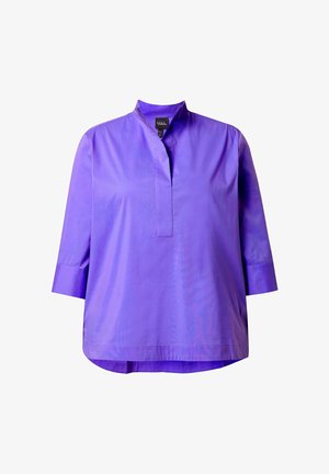 Violetti, kolmen neljänneksen hihainen paita, jossa korkea kaulus ja nappilista. Sileä, kiiltävä kangas, rento istuvuus ja kaareva helma.