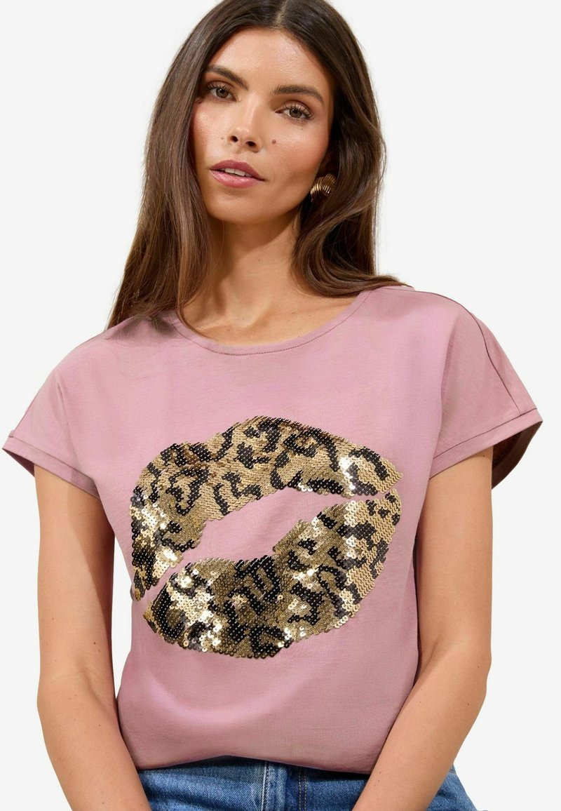 Lyserød T-shirt med korte ærmer, der har et stort lipprint i guld og sort med pailetter, en glat tekstur og en afslappet pasform.