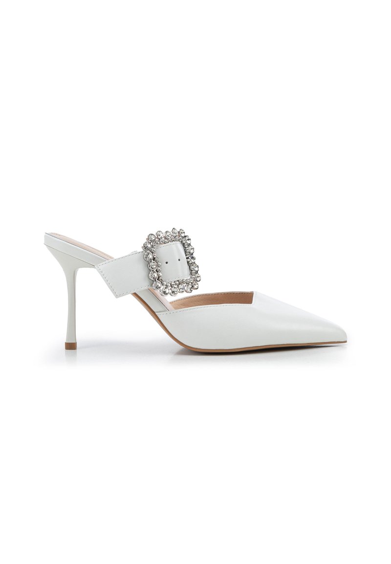 Escarpins blancs à bout pointu avec un talon aiguille et une grande boucle ornée de strass sur la bride. Texture en cuir lisse.