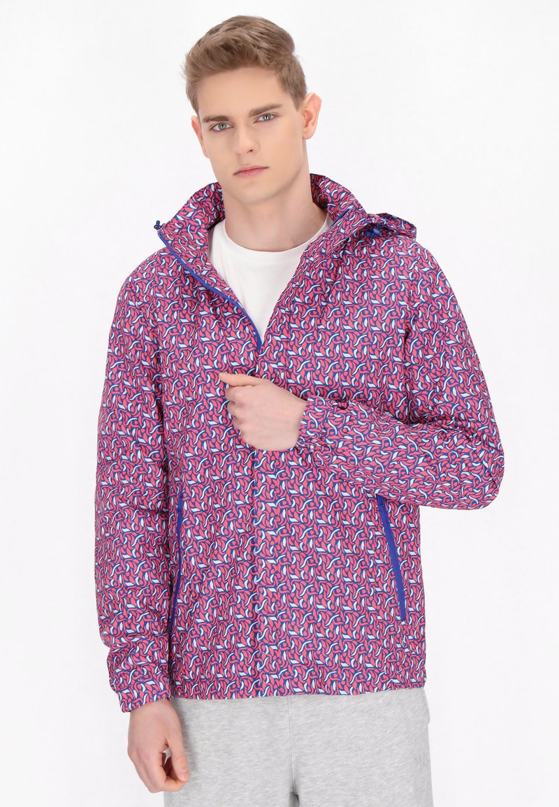 Jachetă ușoară cu glugă, cu un model abstract vibrant în nuanțe de roz și albastru, fermoar frontal, manșete elastice și buzunare laterale.