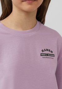 Lila sweatshirt met een geribde halslijn. Het heeft een zwarte grafische afbeelding met de tekst "RAMEN FRESH & DELICIOUS" en "Tokio Ramen Street."